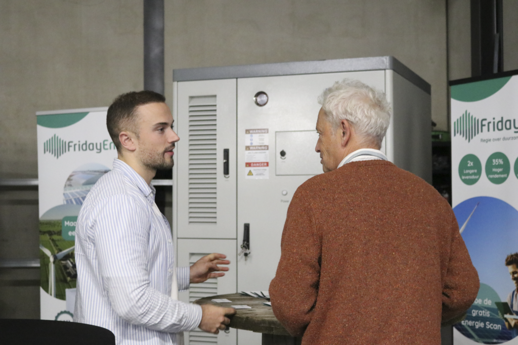 Partnermanager van Friday Energy in gesprek met een partner, met de G1-batterij op de achtergrond