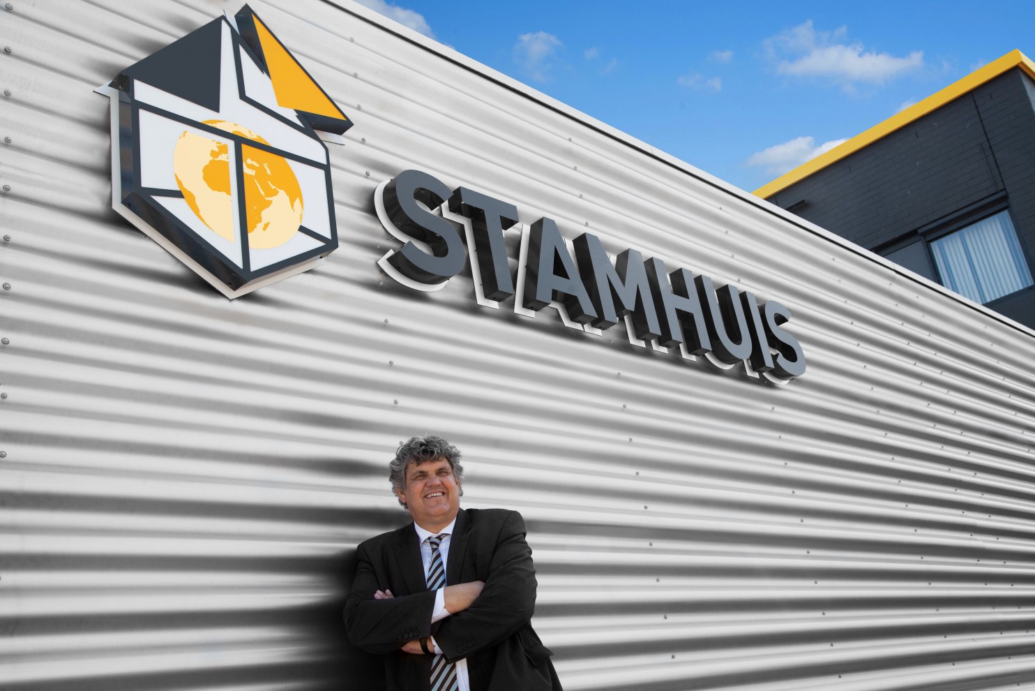 Henk van Stamhuis in Utrecht · voor de bedrijfsgevel met het logo van Stamhuis